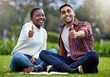 Portrait, students and friends with thumbs up, outdoor or relax on grass, education or promotion for university. Face, people or man with woman in park, hand gesture or like with symbol, sign or icon