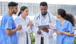 © peopleimages.com - Hospital, teamwork and doctor with group on tablet for advice, support and collaboration. Clinic, healthcare and people outdoor to chat about results, info or planning ideas for surgery with tech