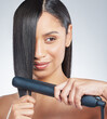 Beauty, straightener and woman with hair care in studio with cosmetics tools on grey background. Salon, equipment and girl with healthy texture from treatment for natural hairstyle with heat
