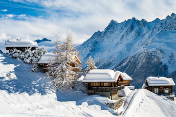 Traditional alpine wooden houses in winter mountain snow landscape, Loetschental valley, Switzerland