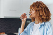 © SHOTPRIME STUDIO - Young African American woman hydrating herself with a refreshing glass of water in her home kitchen
