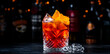 © 5ph - Coffee negroni red cocktail drink with dry gin, vermouth and bitter, espresso, liqueur, orange and ice. Black bar counter background