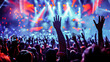 © apratim - Enthusiastic crowd at a live concert with raised hands enjoying the performance under vibrant stage lights.