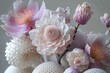 A closeup of an intricate floral arrangement made from detalied white and pink flowers with pastel colored petals. The flowers have unique textures and shapes on gray background.