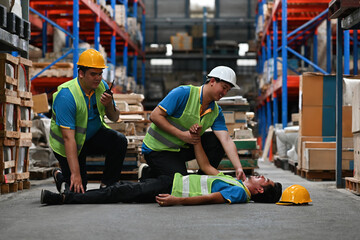 Warehouse workers first aid their friend after accidents or First aid training in an industrial company, safety workplace concept