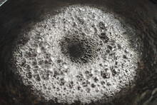 The Water Is Boiling In The Pan. Boiling Water Is Bubbling In A Cast-iron Pan. Close-up. Selected Focus.