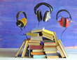 audio book concept with heap of books and 3 floating vintage headphones, literature,education,entertainment, free copy space