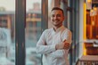 © Fotograf - A man standing with arms crossed by a window. Suitable for business or lifestyle concepts