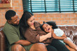 © chokniti - Happy African American Family at Home: Mother and Father Hug Their Young Daughter and Son, Sharing Love and Fun Together, Portraying Cheerful Moments of a Black American Household