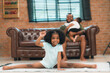© chokniti - Happy African American Family at Home: Mother and Father Hug Their Young Daughter and Son, Sharing Love and Fun Together, Portraying Cheerful Moments of a Black American Household