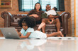 © chokniti - Happy African American Family at Home: Mother and Father Hug Their Young Daughter and Son, Sharing Love and Fun Together, Portraying Cheerful Moments of a Black American Household