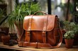 Brown leather sling bag on wooden table with plants in pot