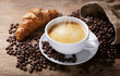 Cup of coffee, croissant and coffee beans