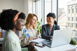 © Marko Geber - Diverse young female colleagues with laptop in modern office