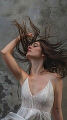 Wall Mural - A woman with long hair is wearing a white dress and is posing for a photo