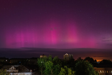 Wall Mural - Aurora borealis over Kharkiv city, Ukraine. Pink Northern lights and starry sky