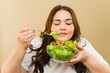 Smiling woman holding a bowl of colorful salad, promoting healthy eating
