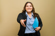 Smiling plus-size woman in business attire extending hand for a handshake, holding a folder