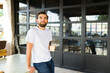 Latin man in white t-shirt and jeans poses casually by a coffee shop, ideal for mockup designs