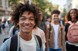 © Enigma - Cheerful teenage boy with curly hair and a backpack smiles while walking with a diverse group of friends on a lively city street, capturing a moment of youthful happiness