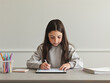 © marcinjozwiak - Asian girl using tablet for studying, focused, looking at the screen directly.