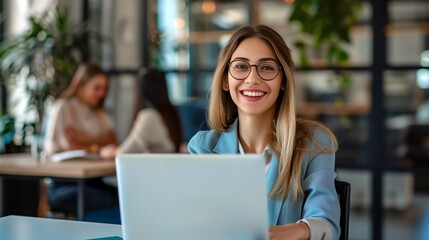 Wall Mural - Happy successful modern young businesswoman working with his laptop at her office looking at the camera