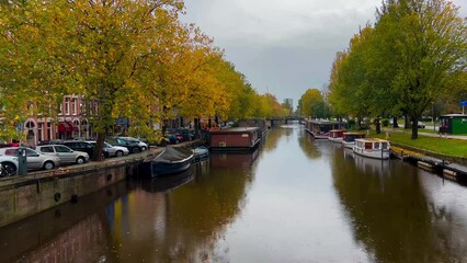 Wall Mural -  Amsterdam autumn cityscape narrow old houses, canals, boats Amsterdam, Netherlands September 20, 2023. High quality 4k footage