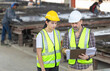 © JU.STOCKER - Engineer and female foreman worker team checking project at precast factory site, Engineer and builders in hardhats discussing on construction site