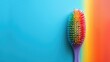 Colorful bristle hairbrush on blue and orange gradient background