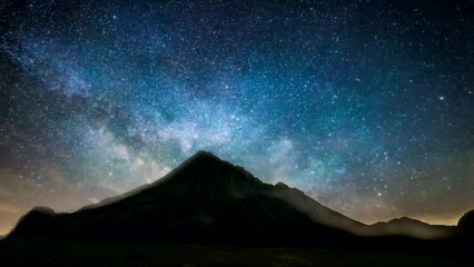 Wall Mural - Silhouette of mountain at night with sky showing beautiful colorful space. looping time-lapse animation video