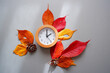 Daylight Saving Time concept background. 
Fall Back decoration colorful leaves and clock composition on gray background. 