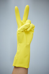 Poster - Cleaning, latex and peace sign with hand for chores or housework in studio on white background. Emoji, hospitality and person in rubber glove for hygiene, protection and safety from bacteria germs