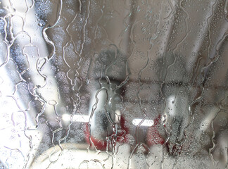 Canvas Print - Car glass at a car wash In drops of water. Background