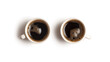 Two cups of black coffee viewed from above on a white background.