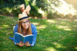 © peopleimages.com - Park, thinking and girl with book for reading, learning and knowledge with smile outdoor. Nature, female student and novel for entertainment, romance and English literature for language improvement