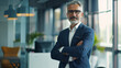 © VK Studio - Confident senior businessman posing in a modern office environment.