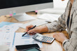 Young woman checking bills, taxes, bank account balance and calculating expenses at desk.
