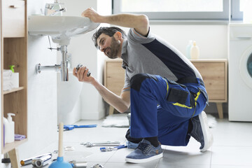 Wall Mural - Plumber repairing a bathroom sink