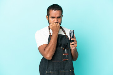 Wall Mural - Young hairdresser latin man isolated on blue background having doubts