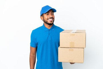 Poster - Delivery Ecuadorian man isolated on white background looking to the side and smiling