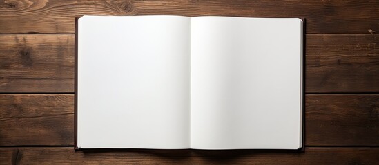 Fototapete - A copy space image of a blank page in an open notebook seen from a top down perspective resting on a wooden table