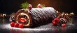 The Christmas Swiss roll cake is beautifully presented on a slate with a rich chocolate fudge topping and adorned with chocolate flakes and festive decorations Ample copy space is available in the im