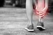 Runner female touching painful twisted or broken ankle. Athlete training accident. Sport sprain cause injury knee leg bones while run in outdoor the park.