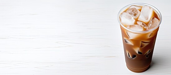 Wall Mural - A refreshing cup of iced coffee placed on a blank white surface providing a perfect copy space image