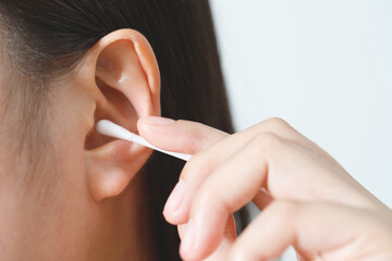 close up female cleaning ear using cotton stick for Healthcare.