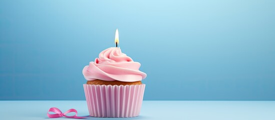 Aufkleber - A homemade cupcake with a lit candle is placed on a simple background creating a cheerful birthday greeting card The copy space image also includes a gift box for the birthday holiday celebration
