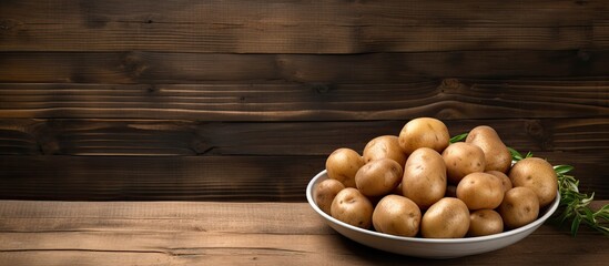 Wall Mural - A copy space image featuring a plate of uncooked potatoes is placed on a rustic wooden table