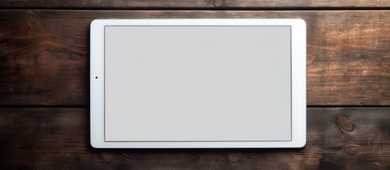 Poster - A white digital tablet is placed on a dark wooden table creating a contrast in colors and textures. Creative banner. Copyspace image