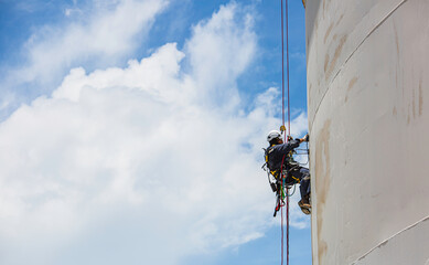 Wall Mural - Male worker down height tank roof rope access safety inspection thickness weld of storage tank.