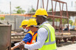 © JU.STOCKER - Foreman and worker team checking project at the precast factory site, Engineer man and builders in hardhats discussing on construction site